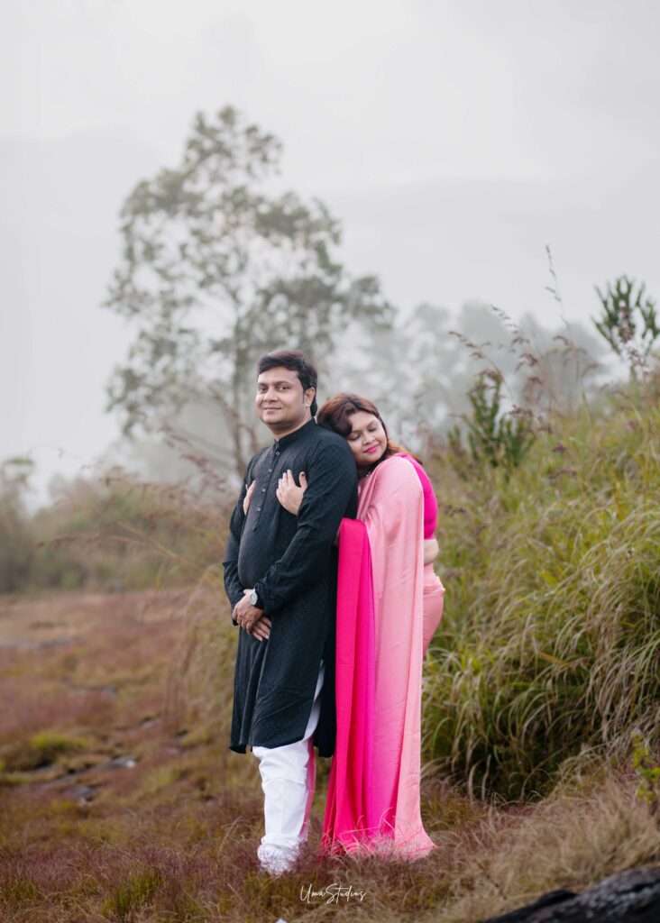 Romantic couple photoshoot in Munnar with a couple in traditional outfits standing amidst misty greenery, captured by Uma Studios Munnar